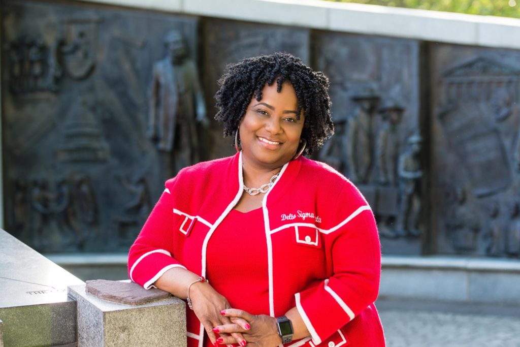 Woman of Delta Sigma Theta Sorority with a sweater, braids and Apple Watch, posing in front of the African American Monument in Columbia, South Carolina  